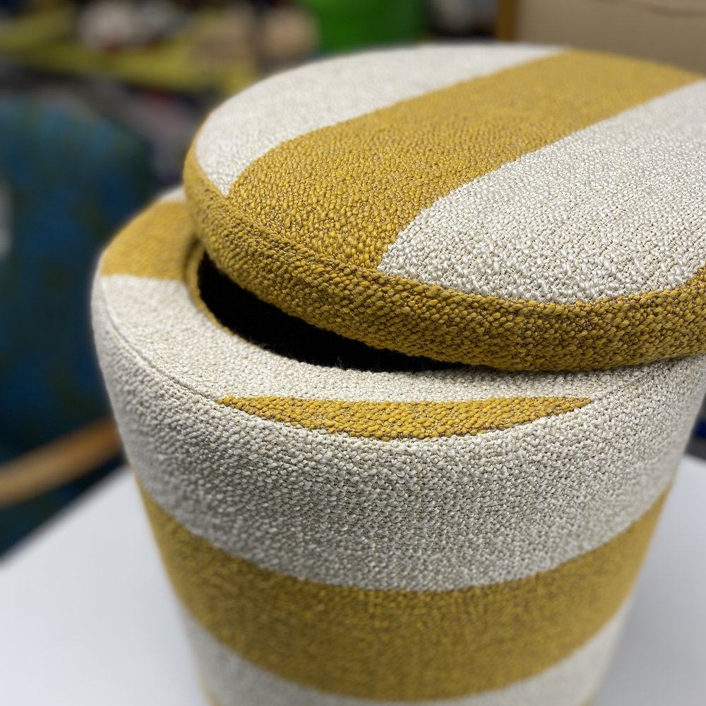Samma sittpuff efter omtapetsering, klädd i gul- och gräddvitrandigt bouclétyg