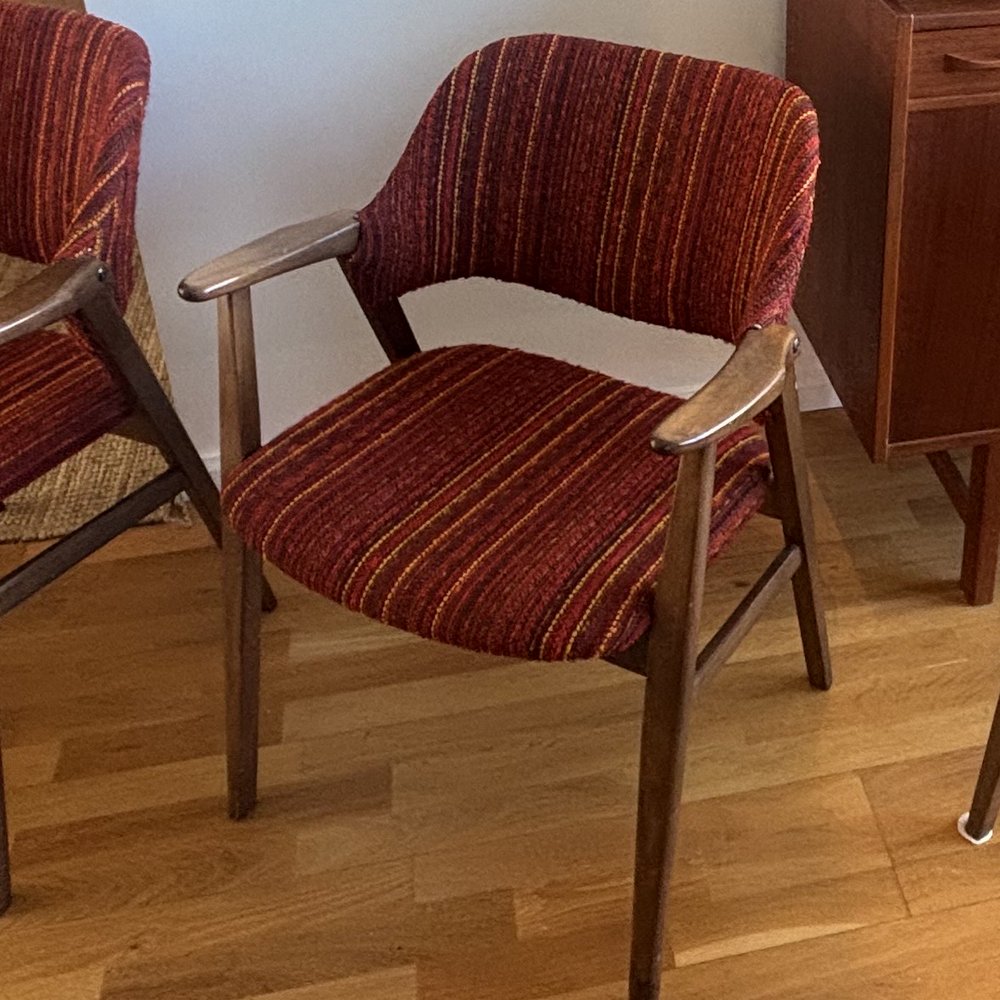 Karmstol i teak före omtapetsering, klädd i rödrandigt slitet tyg